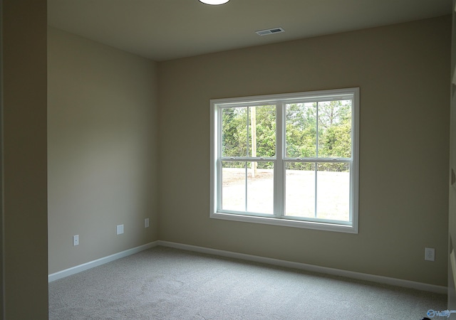 carpeted spare room featuring visible vents and baseboards