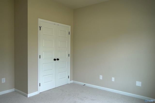 empty room with light colored carpet and baseboards