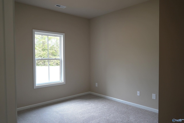 unfurnished room with baseboards, visible vents, and light carpet