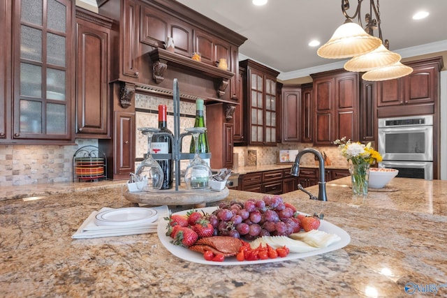 201 Atwater Dr, Madison, AL 35756 - kitchen with double oven, light stone counters, ornamental molding, glass insert cabinets, and backsplash