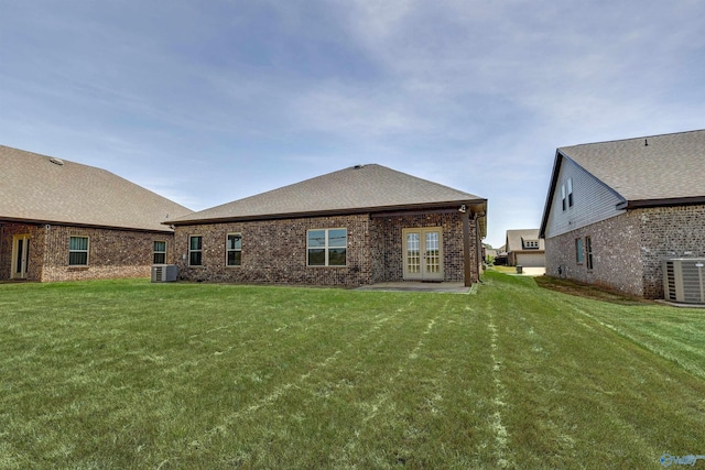 rear view of house with a lawn, french doors, and cooling unit