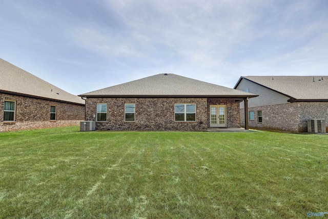 back of house with central AC unit, french doors, and a yard