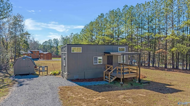 exterior space with a wooden deck, a yard, and a storage shed