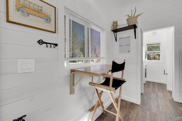 dining area with wood walls and dark hardwood / wood-style flooring