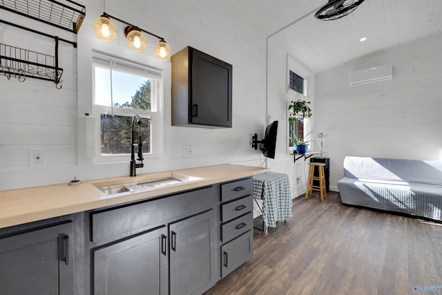 bathroom with a wall mounted air conditioner, vaulted ceiling, wooden walls, sink, and hardwood / wood-style floors