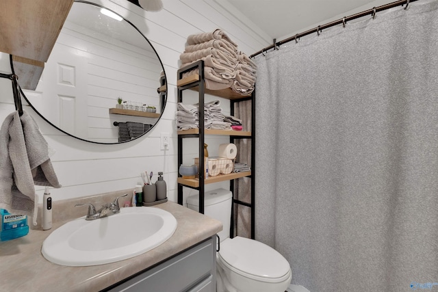 full bathroom featuring a shower with curtain, toilet, wood walls, and vanity