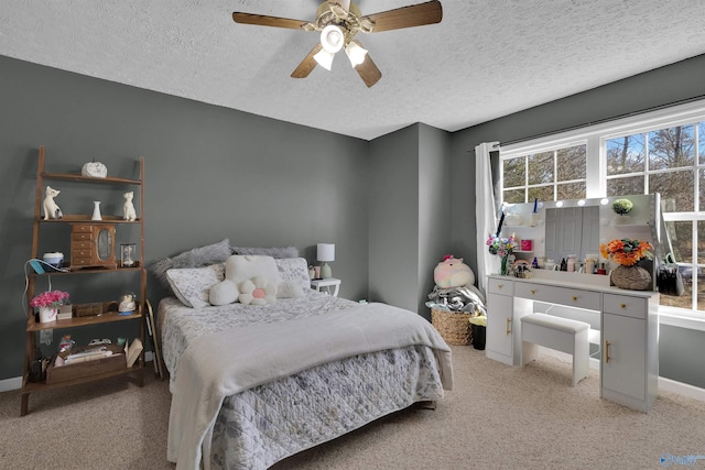 bedroom featuring baseboards, light colored carpet, ceiling fan, and a textured ceiling