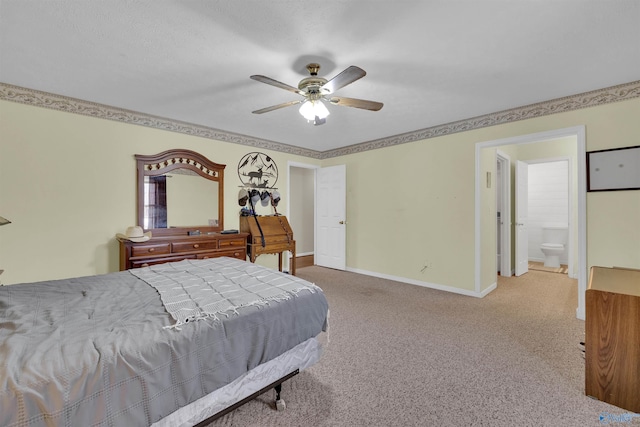 carpeted bedroom with ensuite bath, a ceiling fan, and baseboards