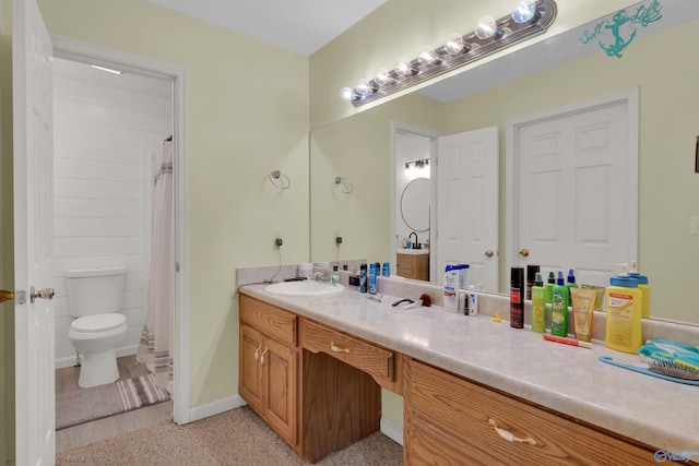 bathroom featuring a shower with shower curtain, baseboards, toilet, and vanity