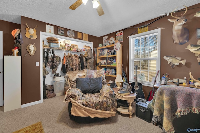 sitting room with carpet, ceiling fan, and a textured ceiling