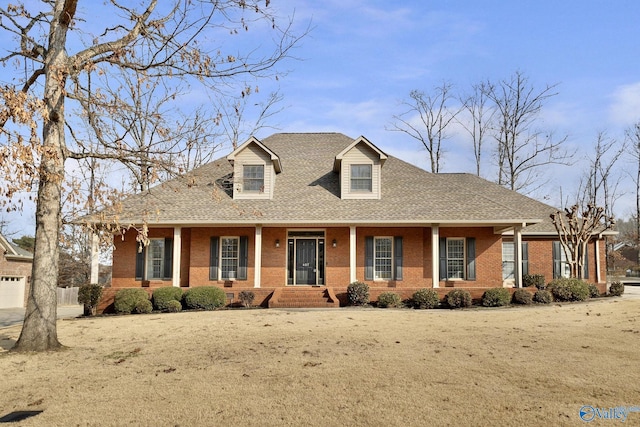 new england style home with covered porch and a front lawn