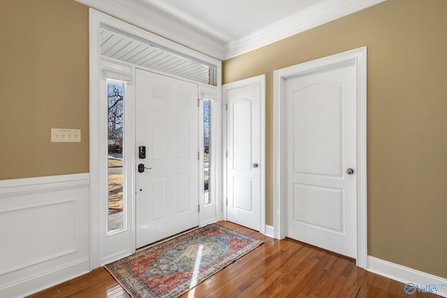 entrance foyer with crown molding and wood-type flooring