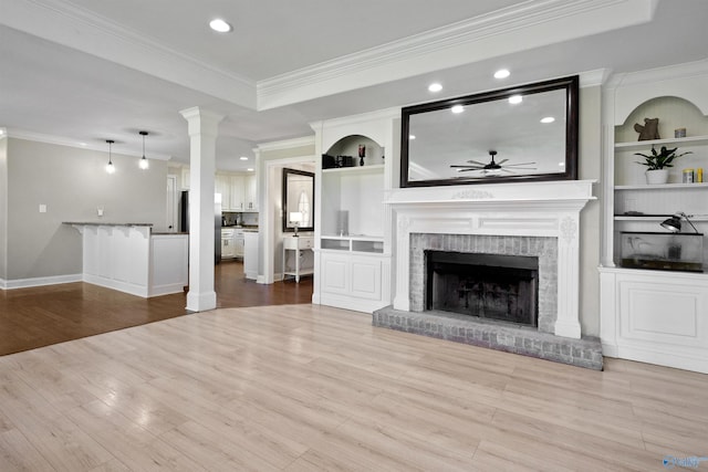 unfurnished living room featuring recessed lighting, a ceiling fan, wood finished floors, crown molding, and a fireplace