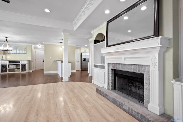 unfurnished living room with baseboards, recessed lighting, wood finished floors, a fireplace, and ornamental molding
