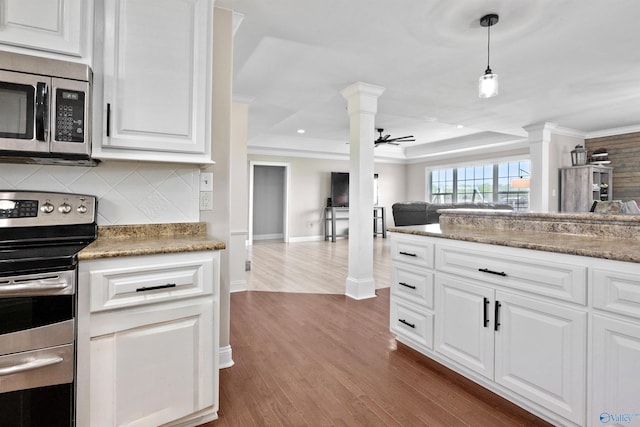 kitchen featuring stainless steel appliances, crown molding, decorative columns, open floor plan, and dark wood-style flooring