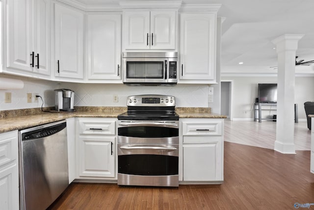 kitchen featuring white cabinets, ornate columns, stainless steel appliances, backsplash, and dark wood-style flooring