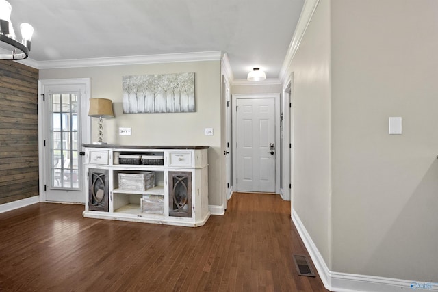 interior space with visible vents, baseboards, and ornamental molding