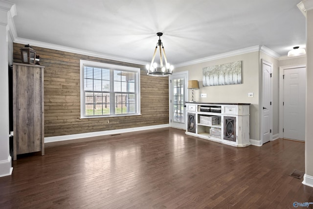 unfurnished dining area featuring wooden walls, wood finished floors, baseboards, and ornamental molding