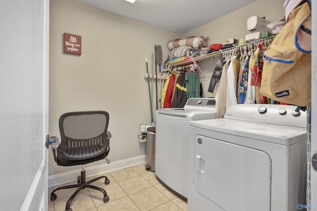 laundry area featuring washing machine and dryer, baseboards, laundry area, and light tile patterned floors