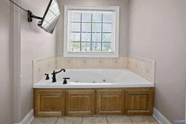 bathroom with tile patterned floors and a tub with jets