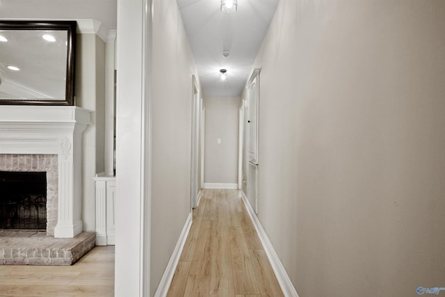 corridor featuring light wood finished floors and baseboards