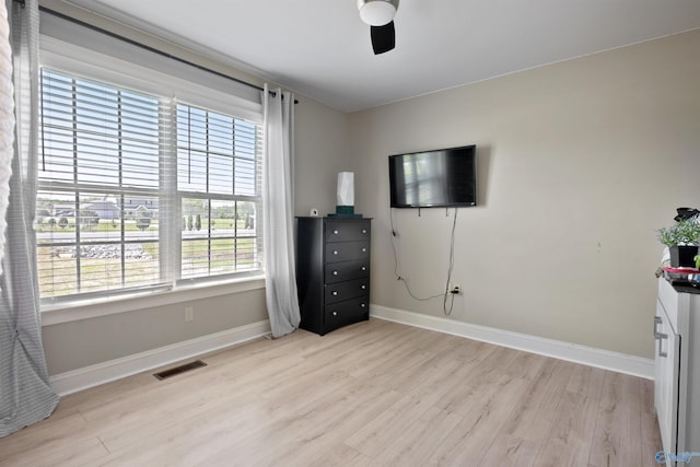 unfurnished bedroom featuring baseboards, a ceiling fan, light wood-style floors, and visible vents