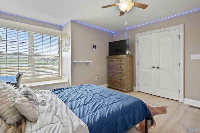 bedroom with wood finished floors, visible vents, and baseboards