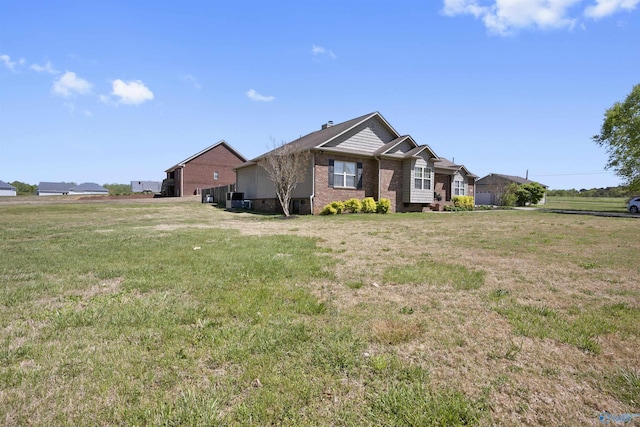 view of home's exterior featuring brick siding and a lawn