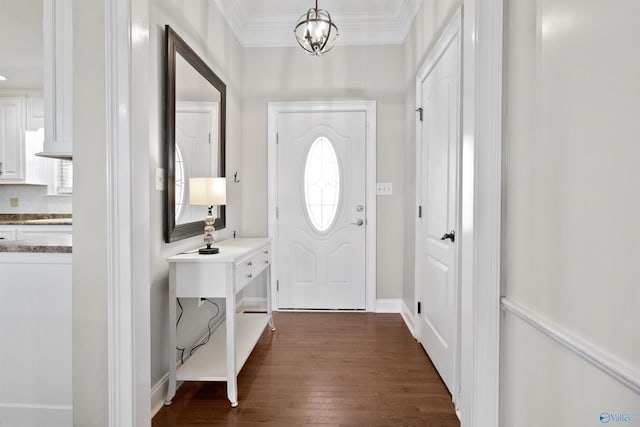entrance foyer featuring a notable chandelier, ornamental molding, and dark wood-style floors