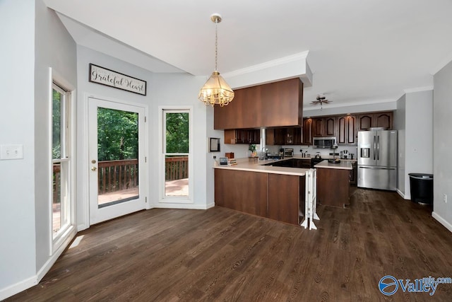 9046 Sugar Tree Trl, Huntsville, AL 35802 - kitchen featuring appliances with stainless steel finishes, light countertops, a peninsula, dark wood-style flooring, and a chandelier