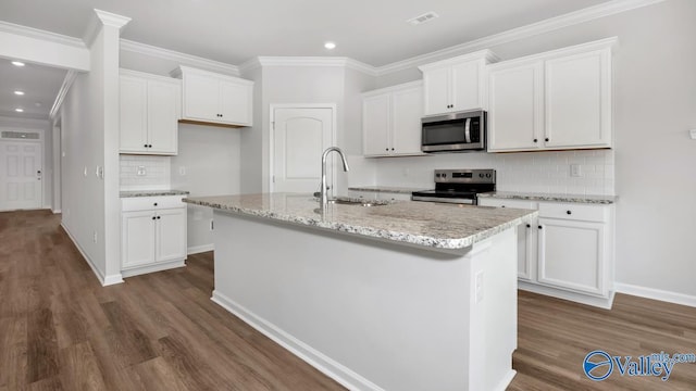 kitchen with white cabinetry, stainless steel appliances, sink, and a center island with sink