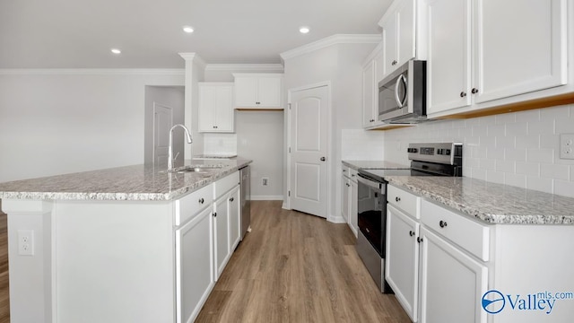 kitchen featuring sink, a center island with sink, stainless steel appliances, light hardwood / wood-style floors, and white cabinets