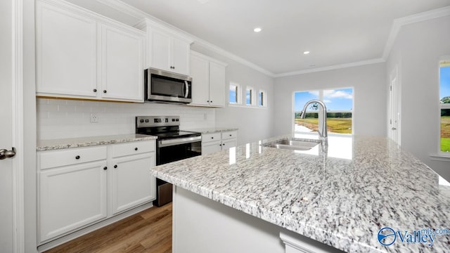 kitchen with sink, a center island with sink, appliances with stainless steel finishes, decorative backsplash, and white cabinets