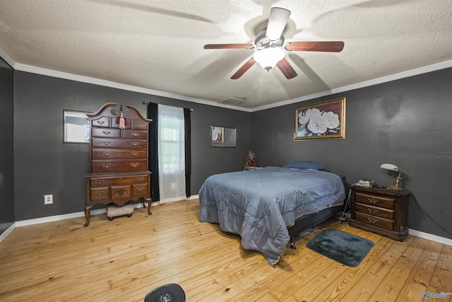 bedroom featuring a textured ceiling, crown molding, baseboards, and hardwood / wood-style flooring