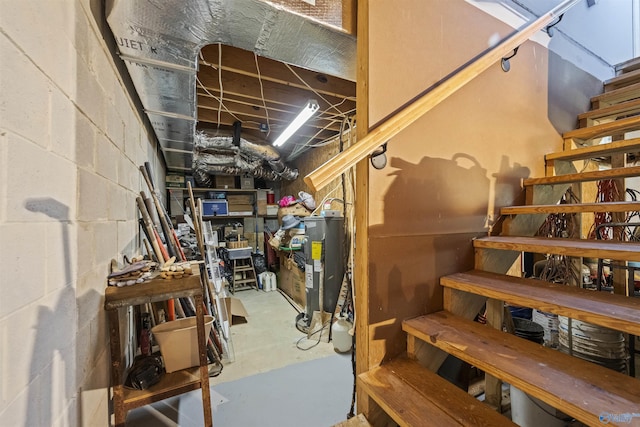 below grade area featuring concrete block wall and water heater