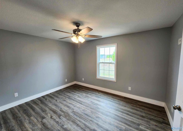 empty room featuring ceiling fan, dark wood-type flooring, and a textured ceiling