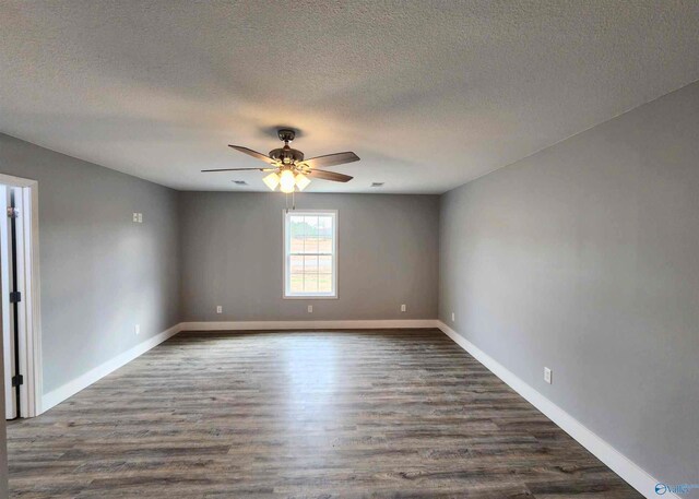 empty room featuring ceiling fan, dark hardwood / wood-style flooring, and a textured ceiling