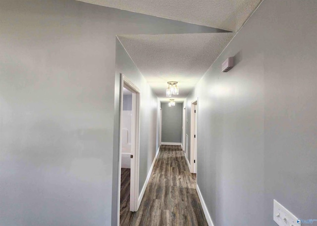 hall with dark hardwood / wood-style floors and a textured ceiling