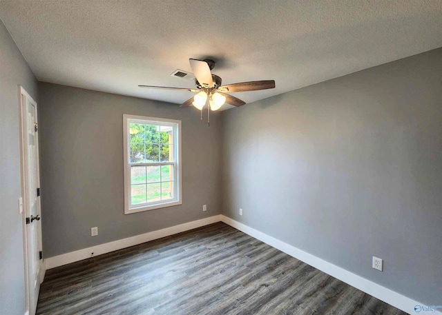 empty room with ceiling fan, dark hardwood / wood-style floors, and a textured ceiling