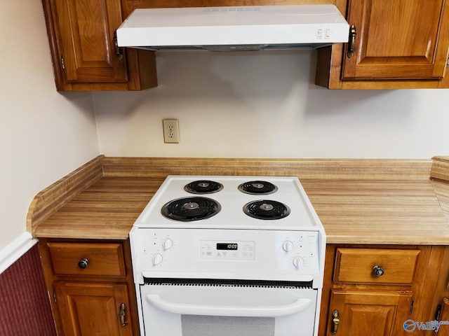 kitchen with range hood, electric stove, a wainscoted wall, light countertops, and brown cabinetry