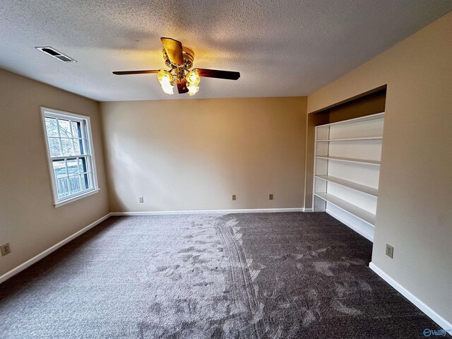 empty room with baseboards, visible vents, a textured ceiling, and carpet flooring