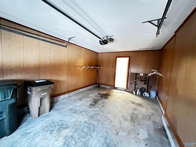 garage with a garage door opener and wooden walls