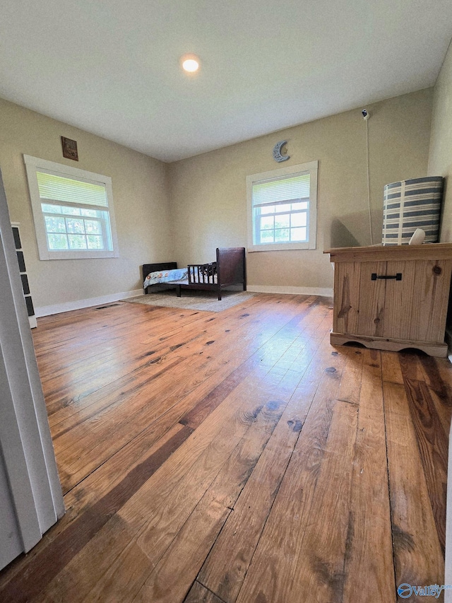 interior space with baseboards, multiple windows, wood-type flooring, and recessed lighting