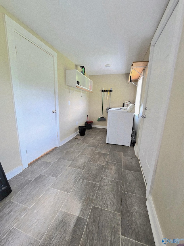 laundry area with laundry area, washer / dryer, and baseboards