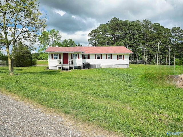 view of front facade featuring metal roof and a front yard