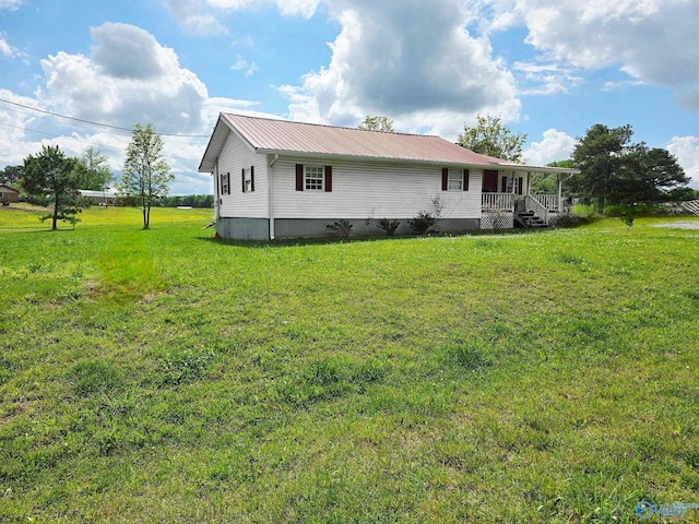 exterior space featuring a porch, a lawn, crawl space, and metal roof