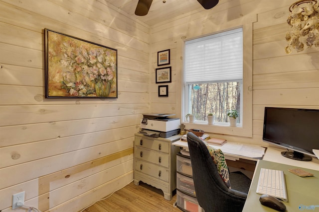 home office with wooden walls, ceiling fan, and light wood-type flooring