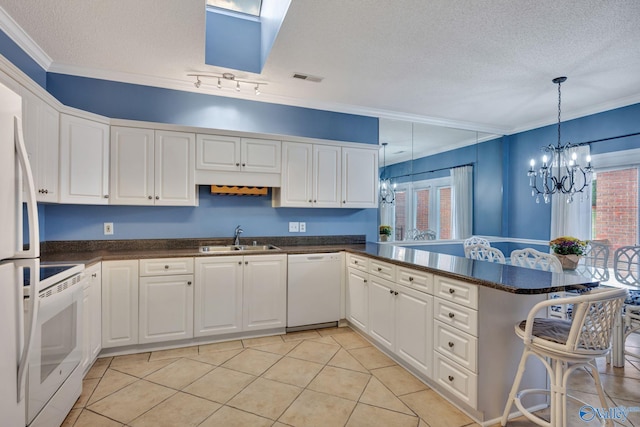 kitchen featuring white appliances, white cabinets, sink, a textured ceiling, and kitchen peninsula