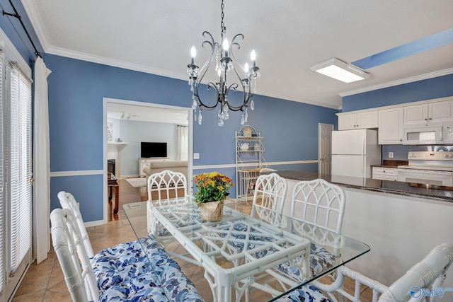 tiled dining area featuring crown molding and a chandelier