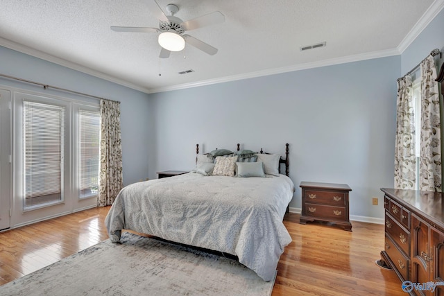 bedroom featuring ceiling fan, ornamental molding, a textured ceiling, and light wood-type flooring